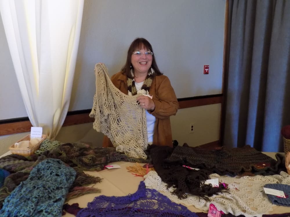 Connie Quiring with her beautiful crocheted shawls, scarves and hats.